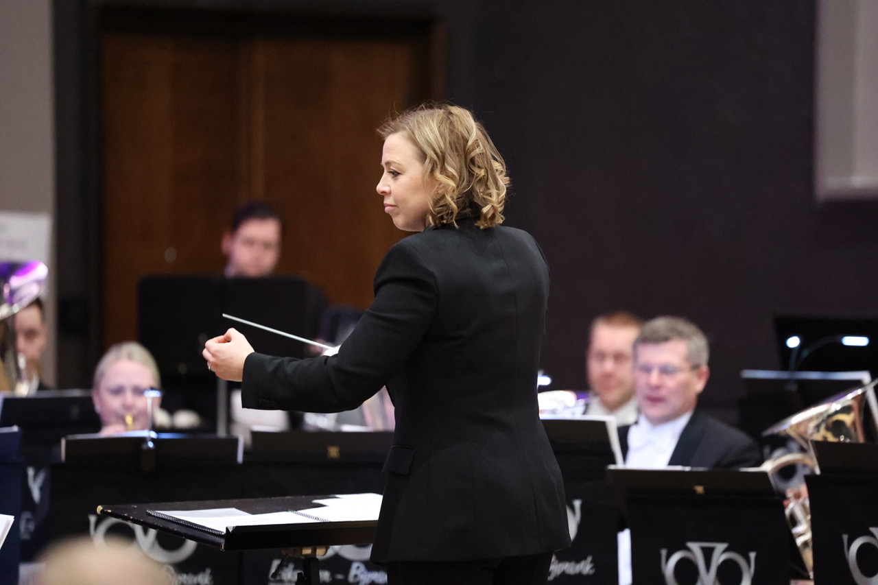 Katrina Marzella conducting a brass band Association logo
