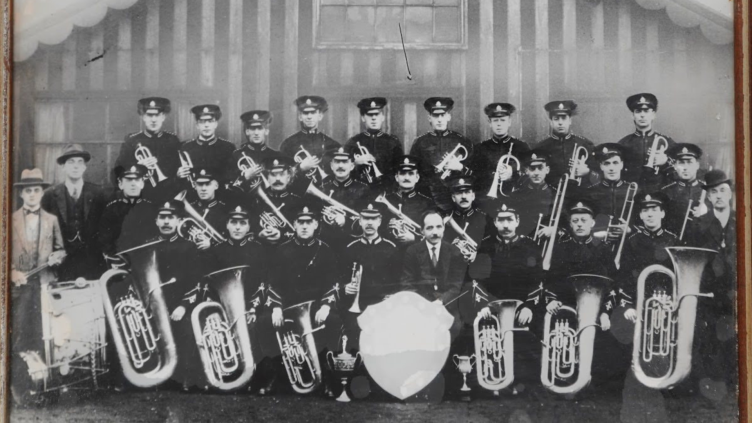 a black and white photograph of banders in their uniform, lined up for the camera